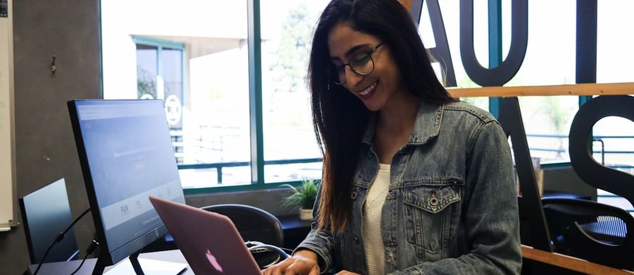 Someone working on a laptop in a bright office